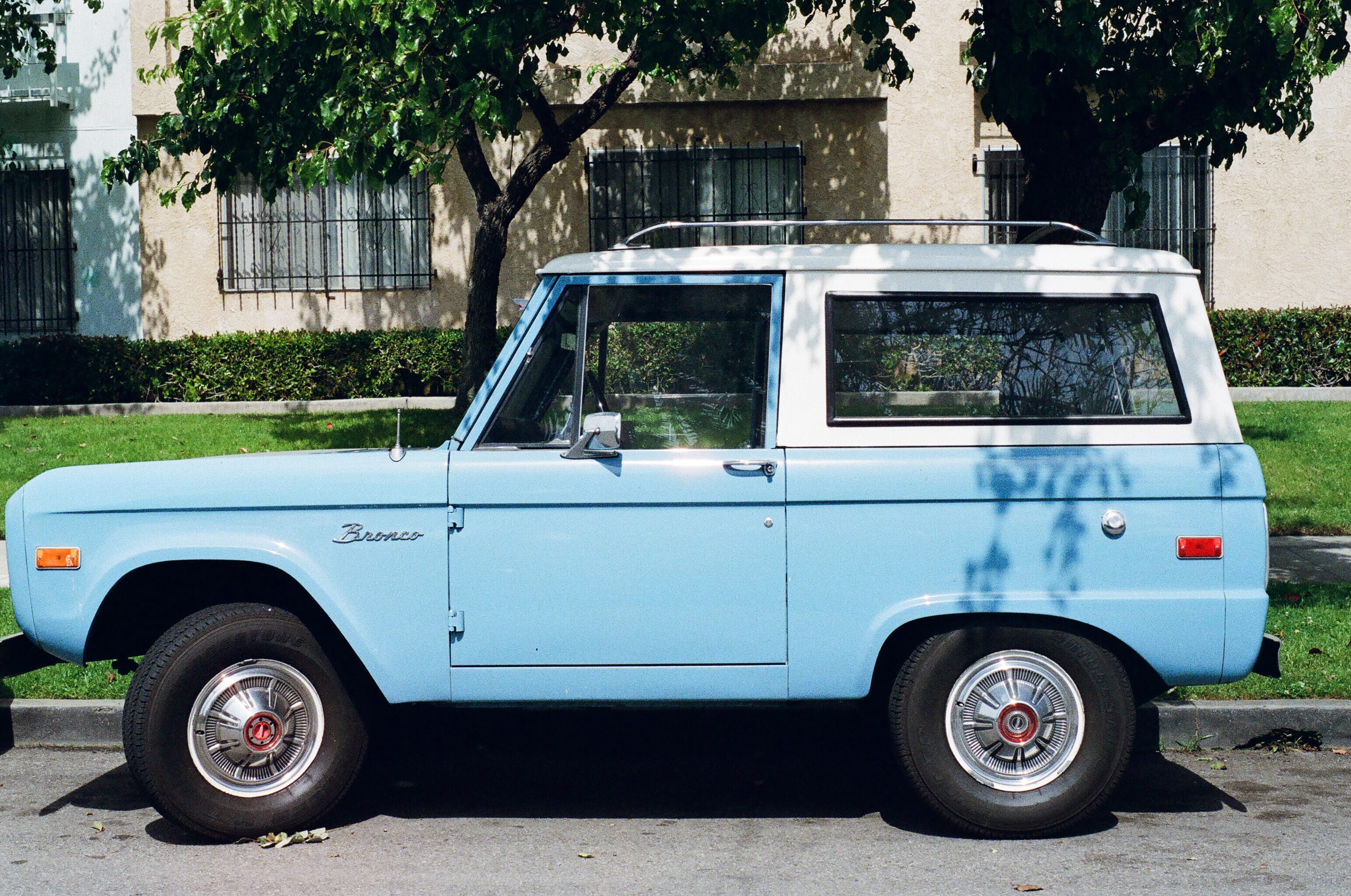 Vintage baby blue Ford Bronco parked on a the street side